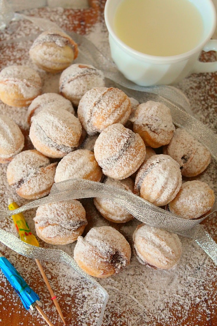 Walnut shaped cookies made with walnut cream,, next to a cup of milk
