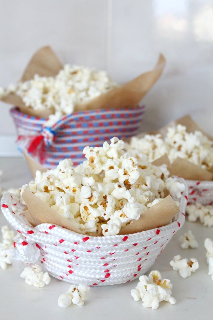 Rope bowl holding cooked popcorn wrapped in parchment paper