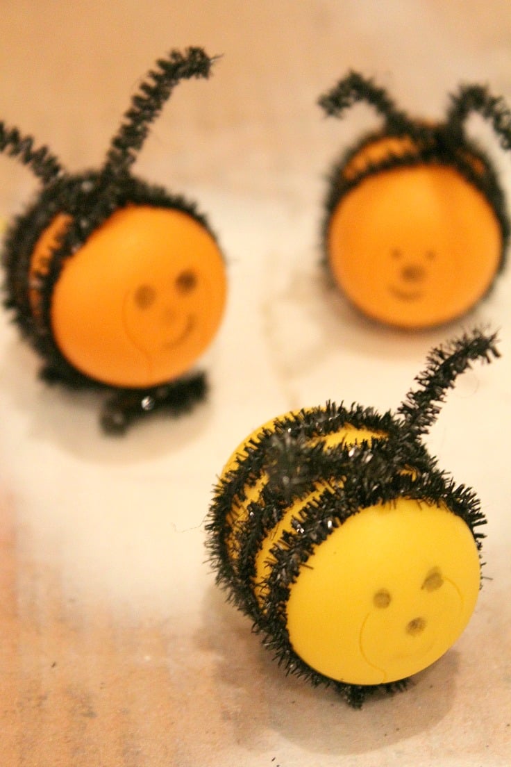 Bee craft for kids from recycled Kinder egg shells and black chenille pipes