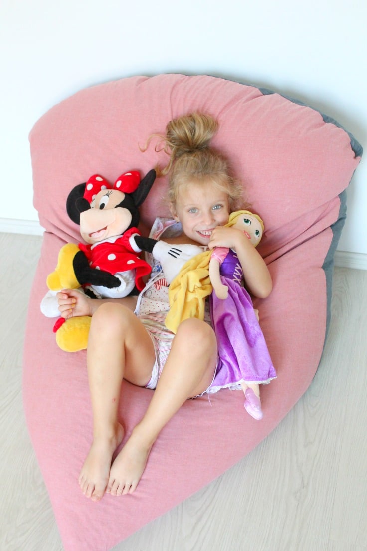 Little girl with dolls sitting on a DIY bean bag chair