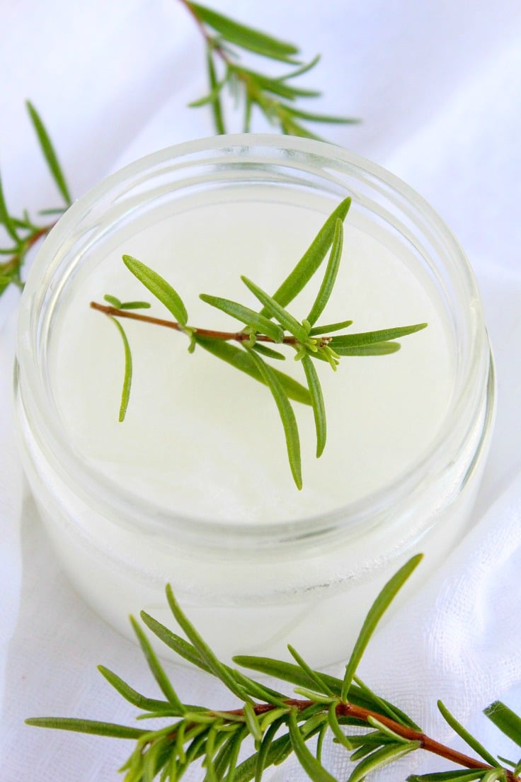 Homemade Vapor Rub in a jar decorated with rosemary sprigs