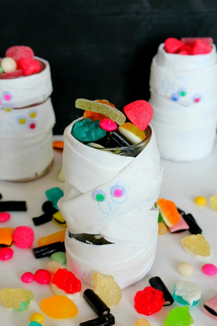 Halloween mason jars for treats made with toilet paper and googly eyes