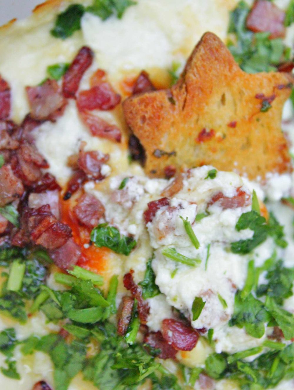 Garlic bread dip with bacon, cheese and parsley served with bread chips