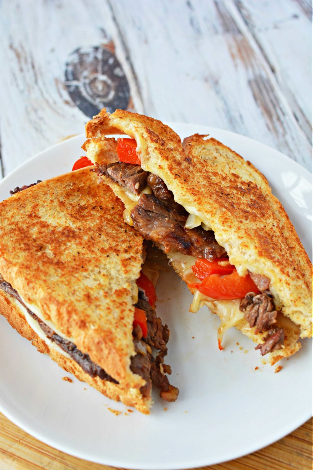 Philly cheesesteak grilled cheese with onion, red bell peppers, hot sauce and provolone cheese