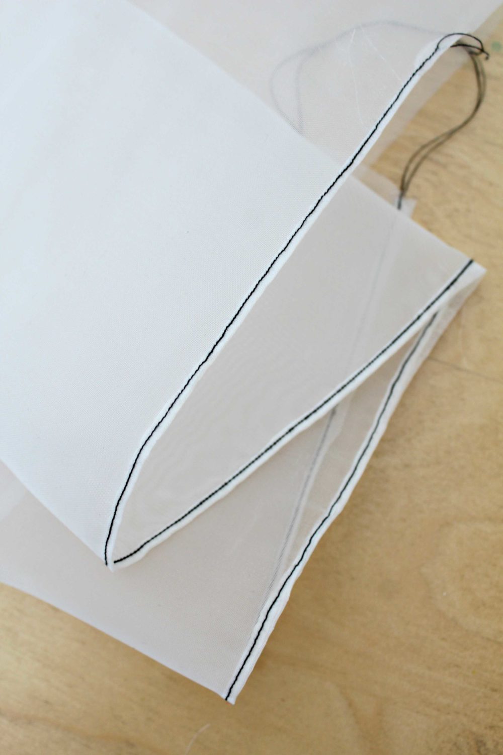 Piece of fabric with a rolled hem showing how to sew a rolled hem