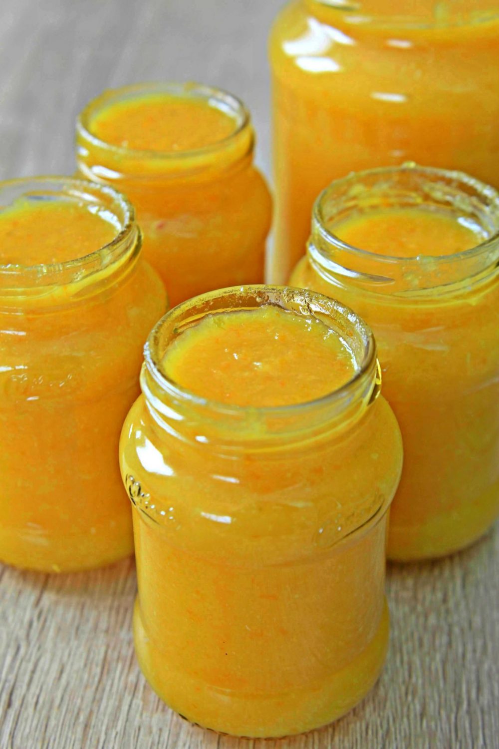 Jars filled with orange lemon marmalade, on a table