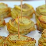 Parmesan potato stacks with garlic and herbs on a white serving plate