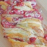 Strawberry puff pastry braid with cream cheese, on a cutting board