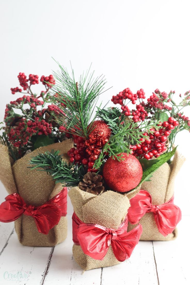 Festive Christmas centerpieces arrangement with candles, ornaments, and greenery