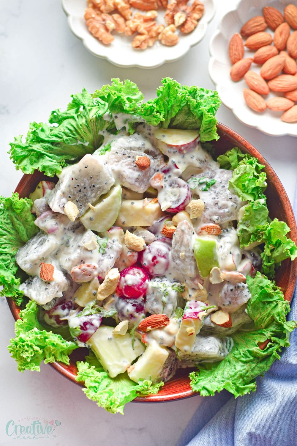 Top view of a brown salad bowl filled with dragon fruit salad made in the Waldorf salad style