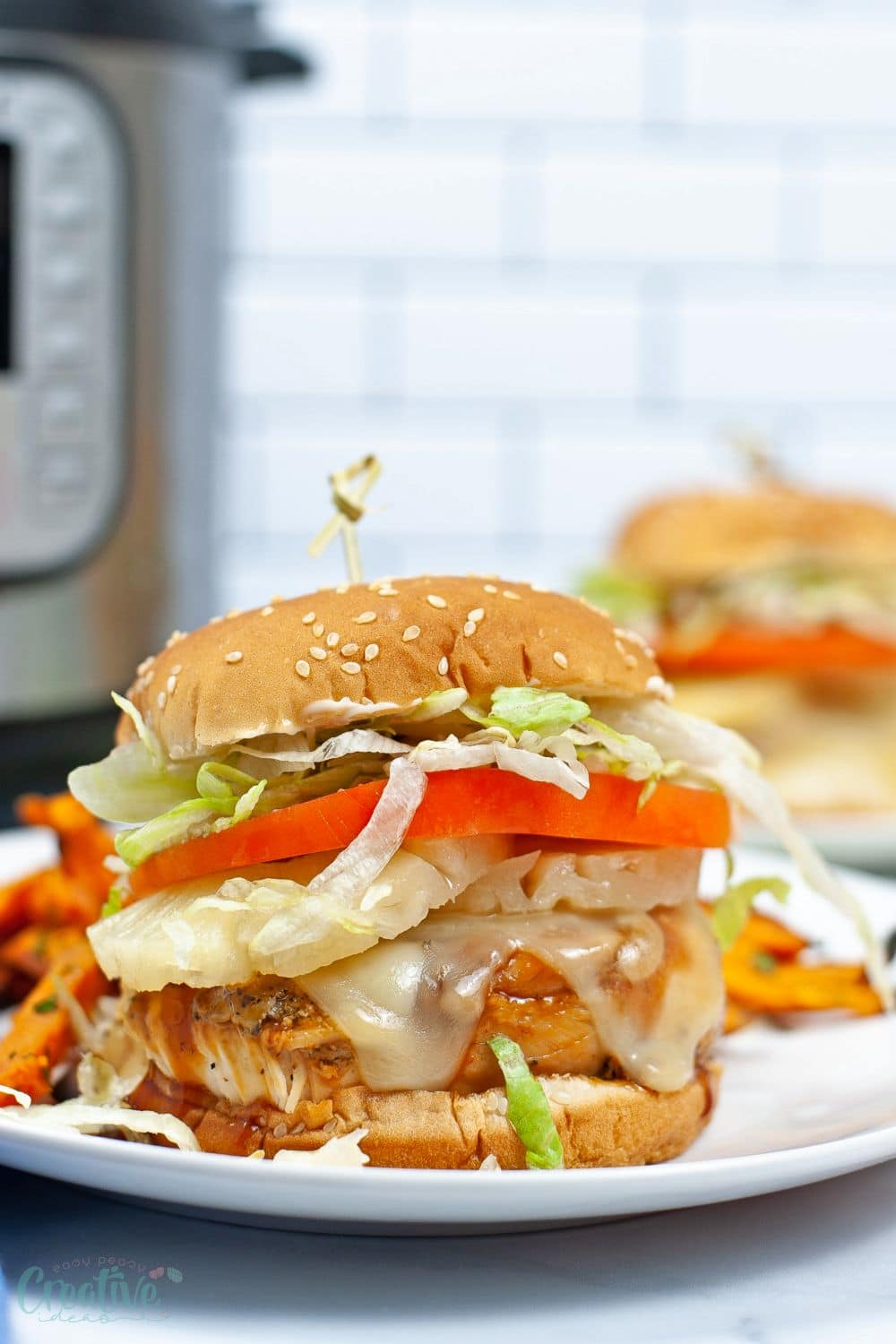 Close up image of Instant Pot chicken teriyaki served in a burger bun with lettuce and cheese