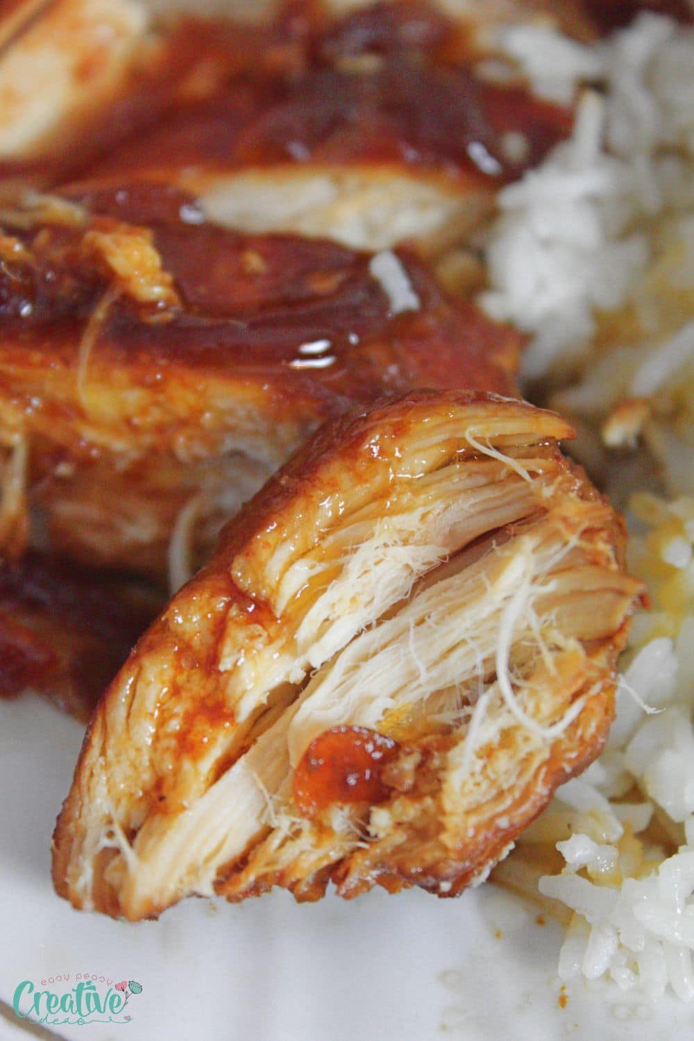 Close up image of a bite of bourbon chicken cooked in the crock pot