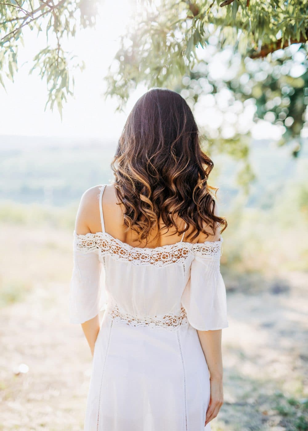 Long haired woman wearing a bohemian white dress