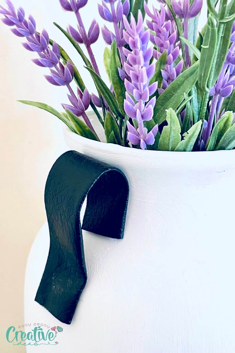 Close up image of a faux leather handle on a Dollar Tree vase DIY