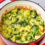 A mouthwatering chicken rice casserole with broccoli, cooked to perfection, served in a red pot for a pop of color.