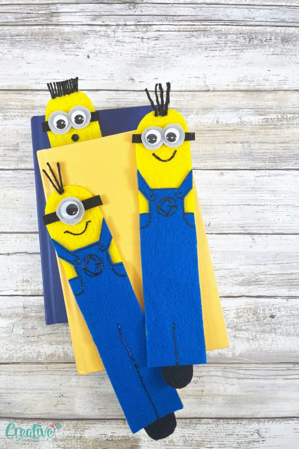 Three adorable DIY minion bookmarks with colorful felt eyes and hair, perfect for marking your place in any book!