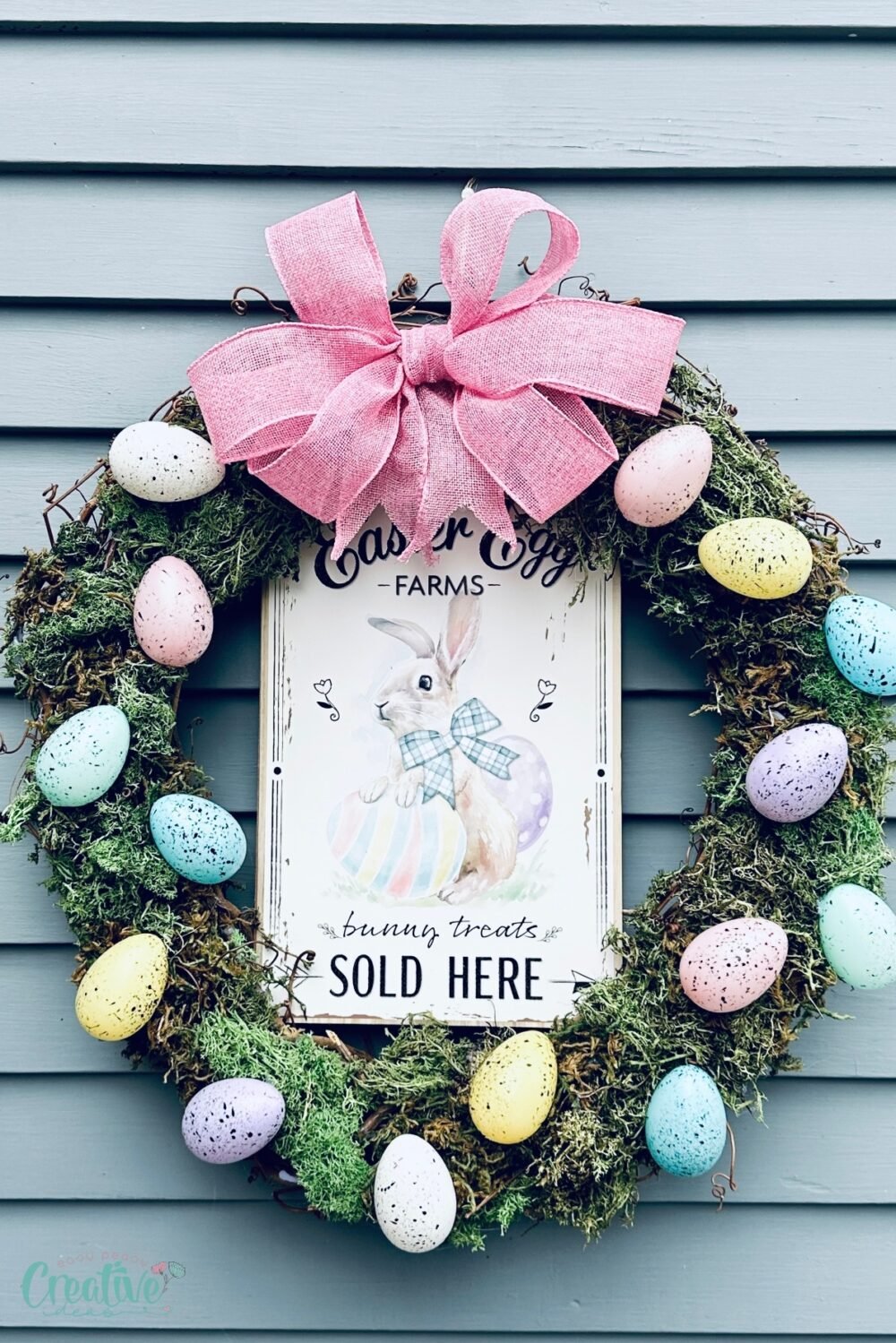 A cheerful Easter door wreath adorned with vibrant eggs and a sign, a lively touch to your home décor.