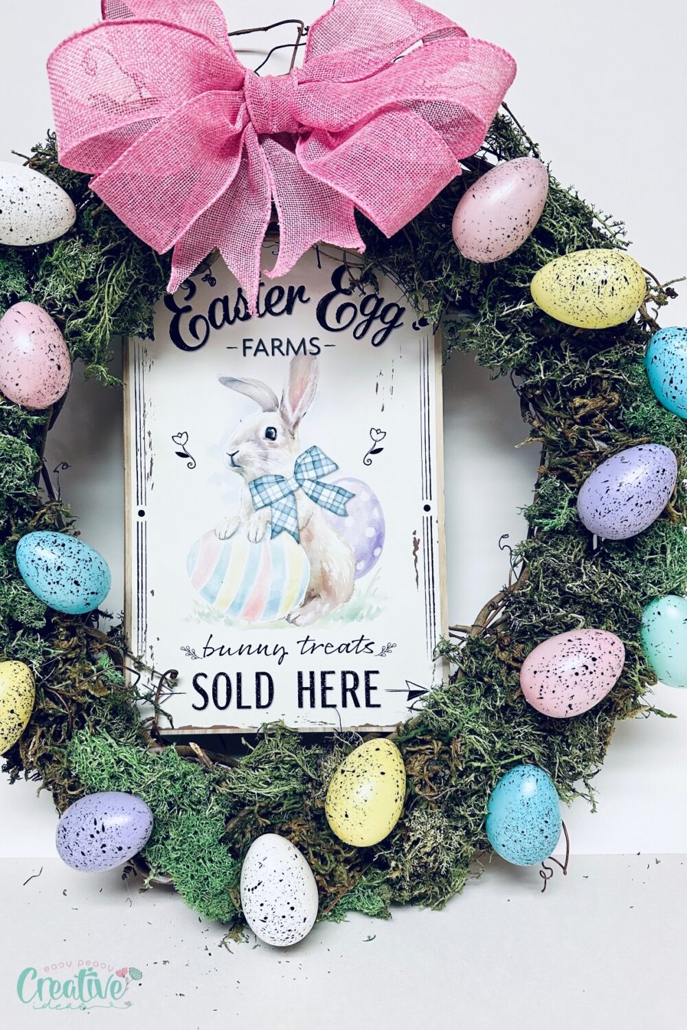Colorful Easter wreath DIY with eggs and a sign, perfect for spring décor.