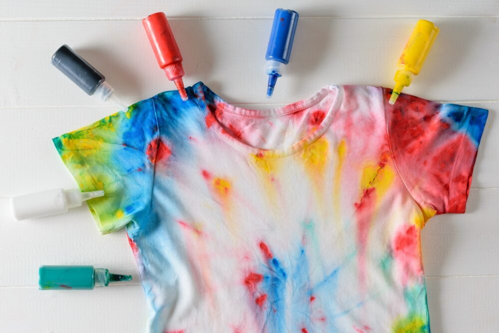 A vibrant tie dye shirt created with markers and paint, showcasing a beautiful array of colors, illustrating a technique for hoe to tie dye at home.