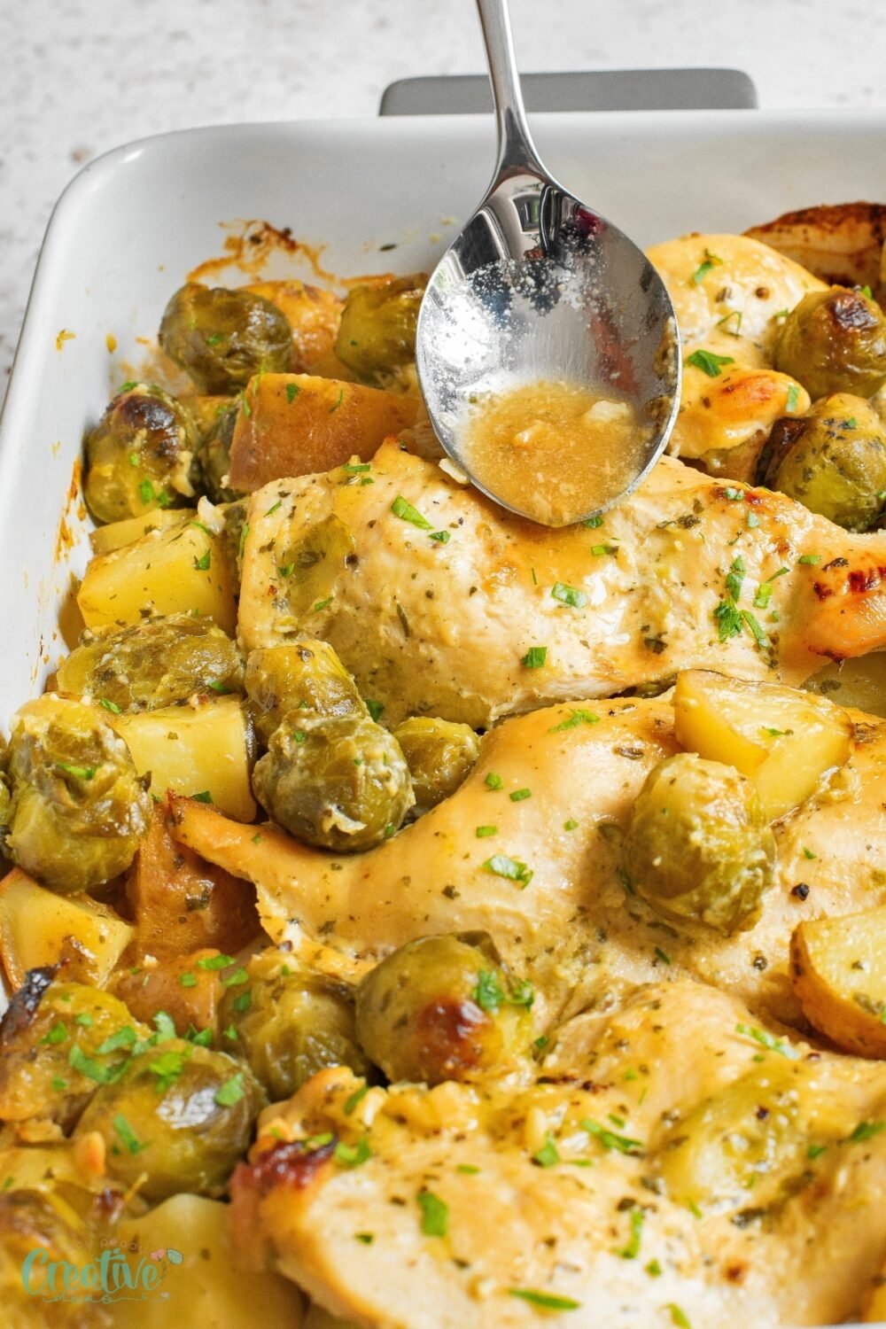 Savory honey and Dijon mustard chicken breast paired with roasted Brussels sprouts and potatoes in a cozy baking dish.